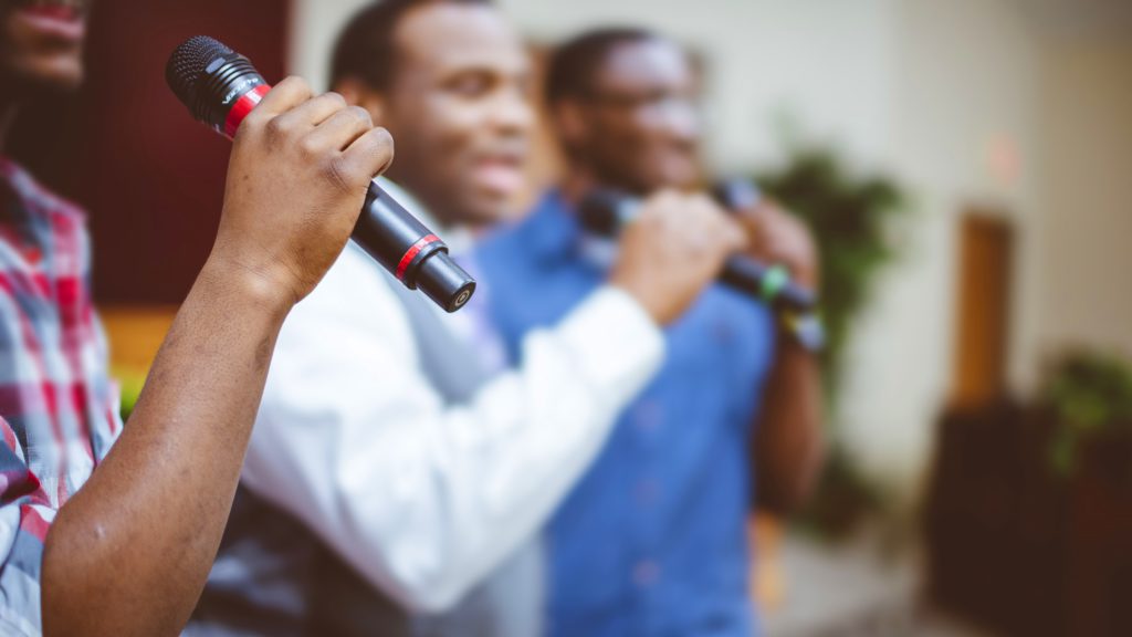 A group of friends singing with microphones at the church